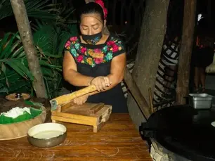 Mujer preparando tortillas a mano con una prensa tradicional en Mamazzita
